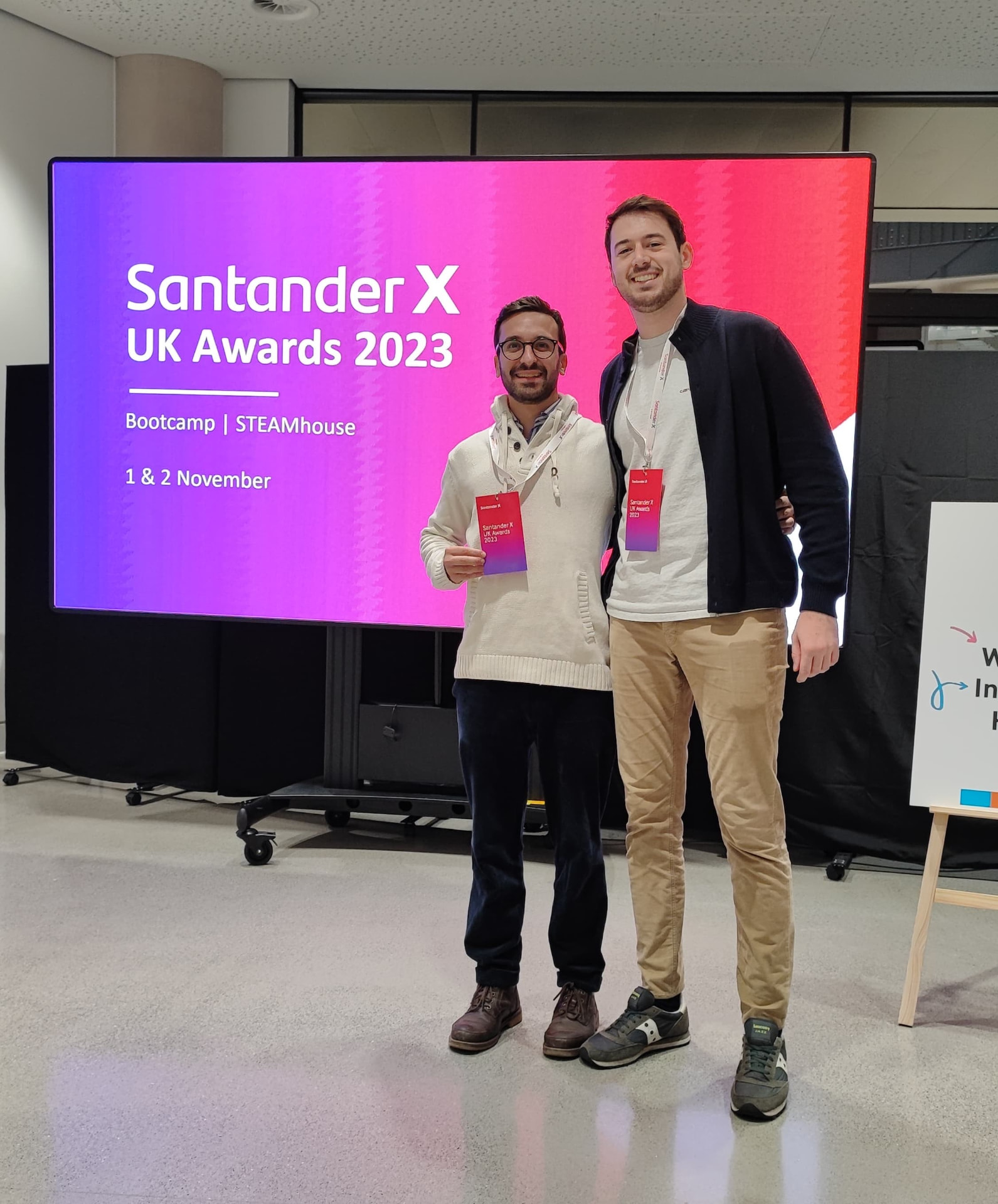 Glassless co-founders at the Santander X UK Awards 2023 bootcamp at STEAMhouse, in front of the Santander X UK Awards 2023 screen